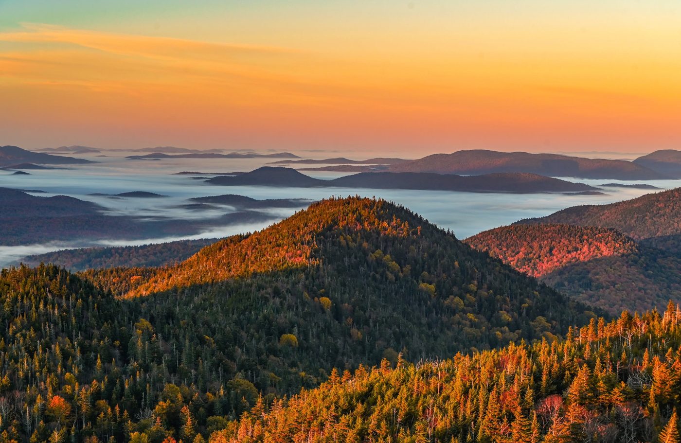 Golden sunrise over layered Adirondack ridges and fog
